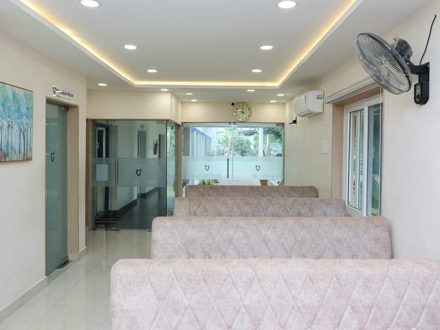 காத்திருக்கும் இடம் — The waiting lounge at Sugapriya Hospital, with daylight and trees outside